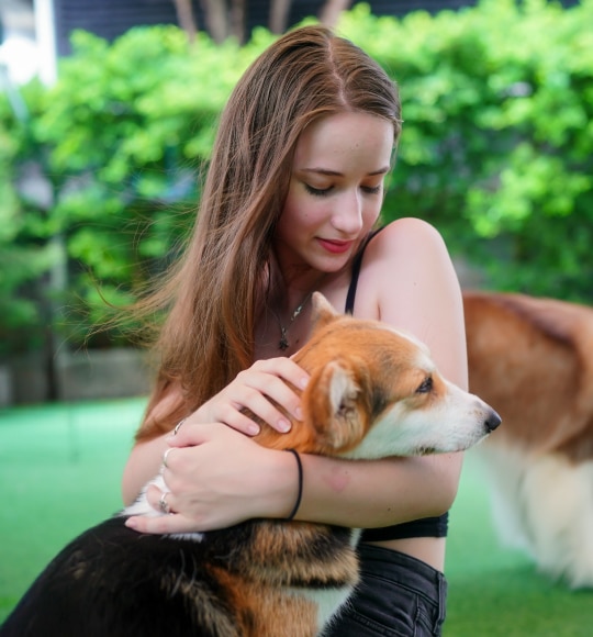 Girl in black outfit petting her dog