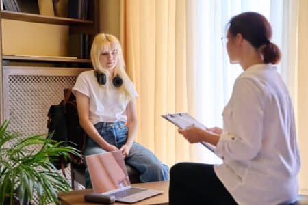 Woman psychologist working with teen blonde girl