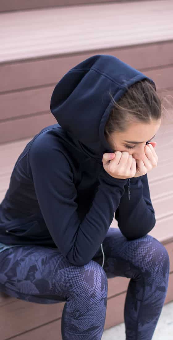 Worried, sad and depressing young woman sits outside